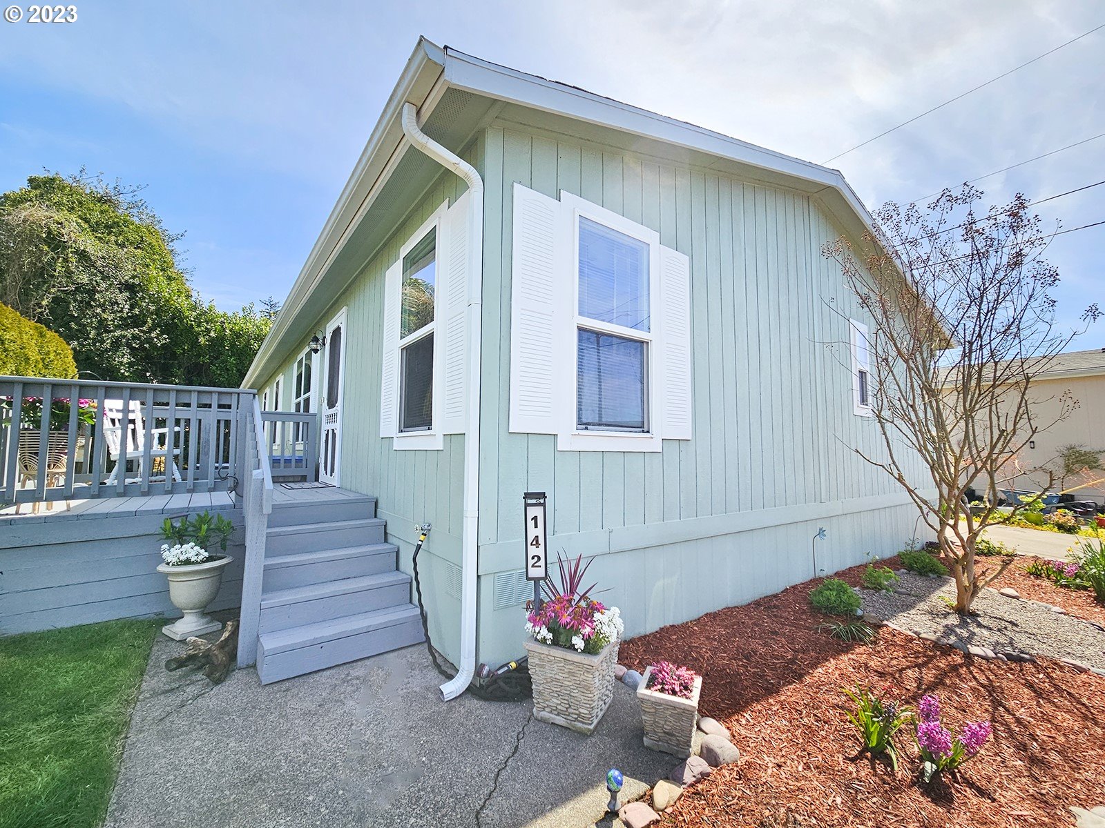 12450 Southwest Fischer Road, Unit 142 Tigard, OR 97224 - Photo 2 of 35 a view of a house with wooden walls and flower plants