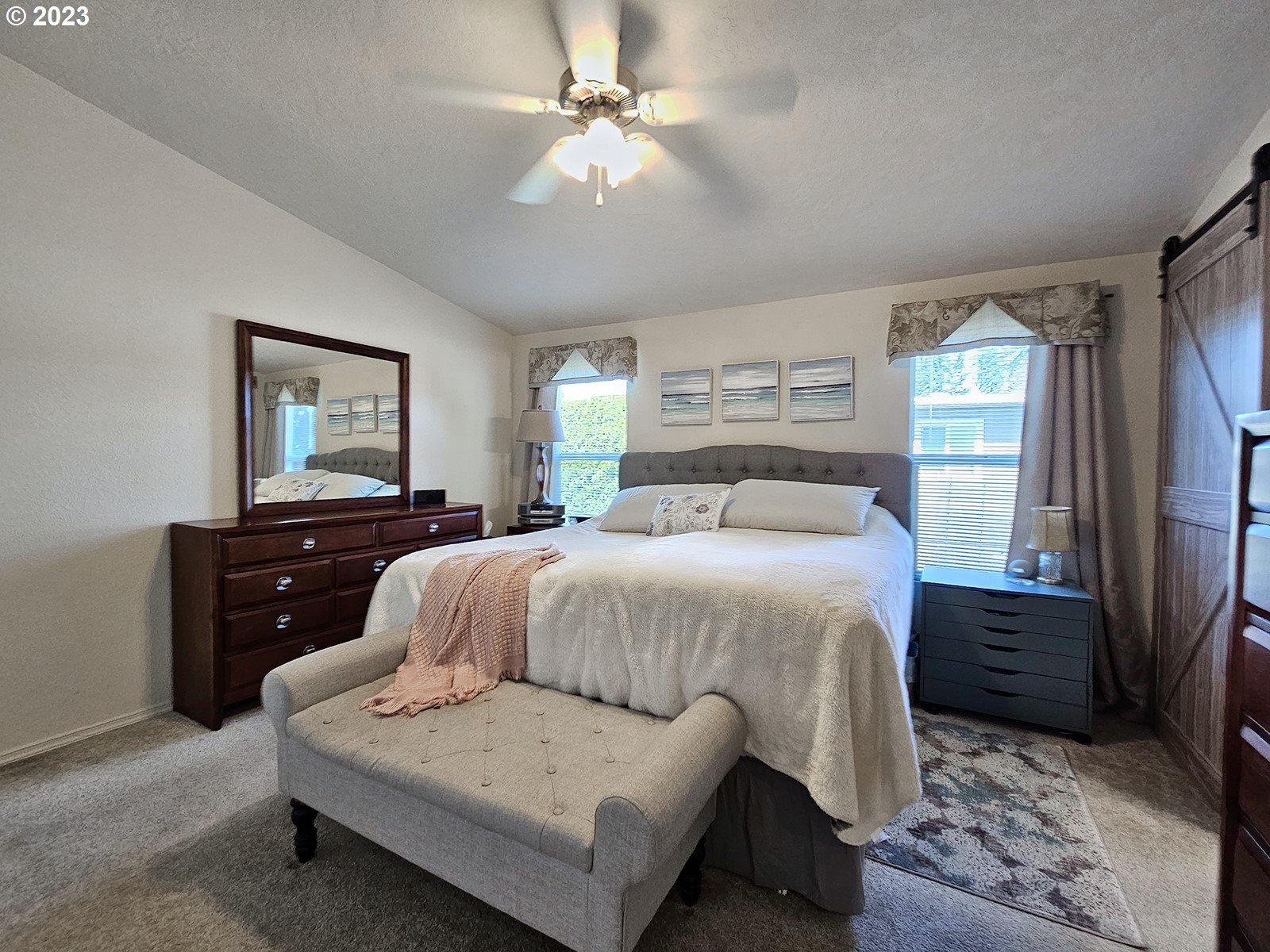 12450 Southwest Fischer Road, Unit 142 Tigard, OR 97224 - Photo 22 of 35 a bedroom with a bed lamps cabinets and a window
