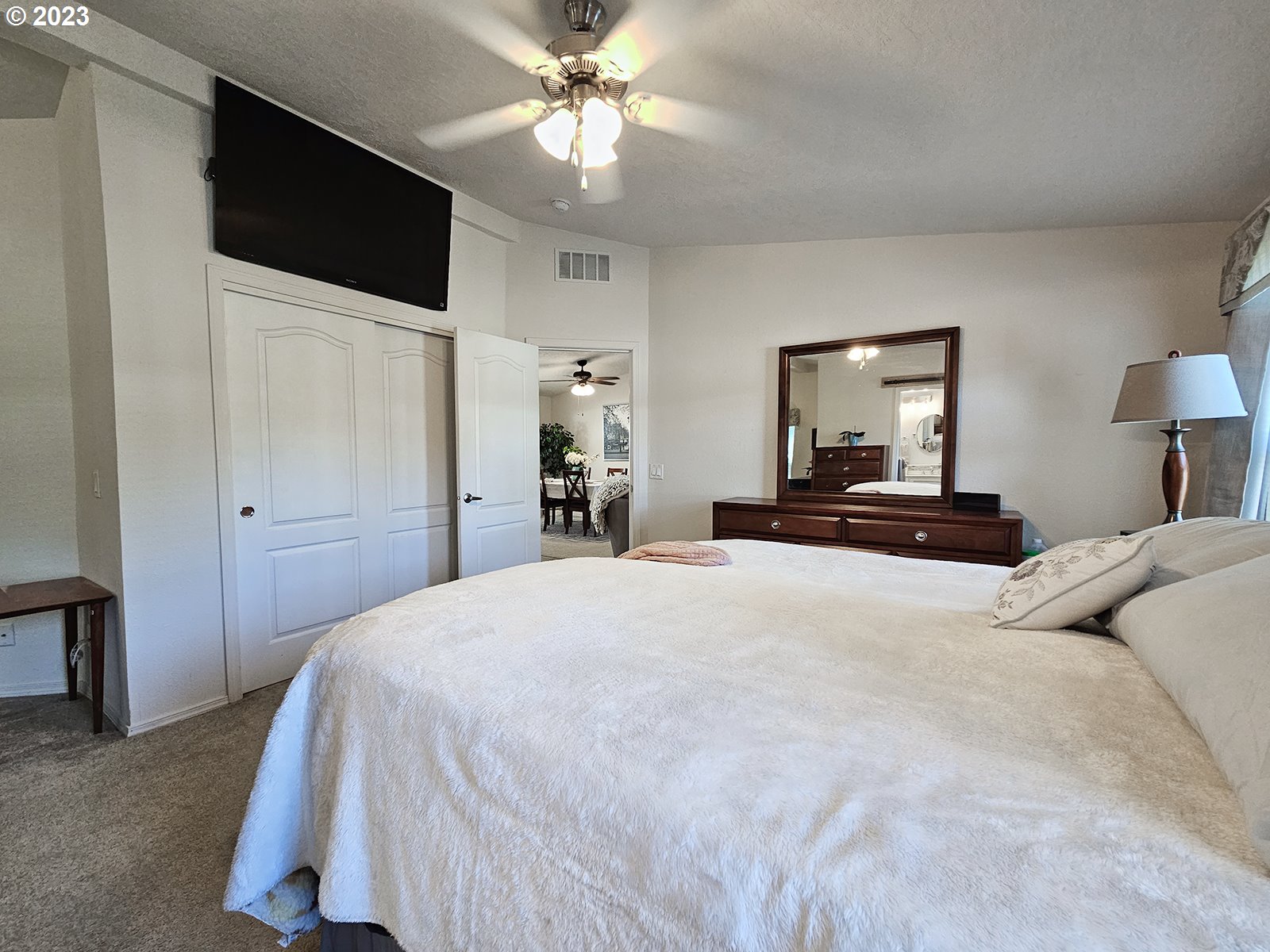 12450 Southwest Fischer Road, Unit 142 Tigard, OR 97224 - Photo 23 of 35 a bedroom with a bed and a flat tv screen on dresser