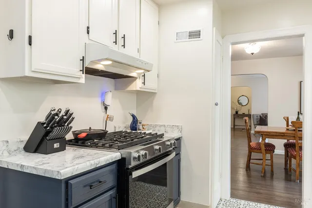 a kitchen with stainless steel appliances granite countertop a stove and cabinets