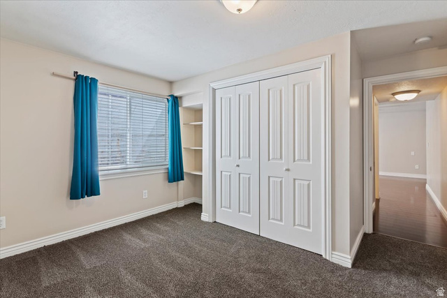 2350 South Highway 89, Unit 4 Perry, UT 84302 - Photo 15 of 30 Unfurnished bedroom featuring dark carpet and a closet