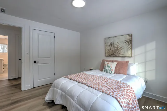 a bedroom with a bed and wooden floor