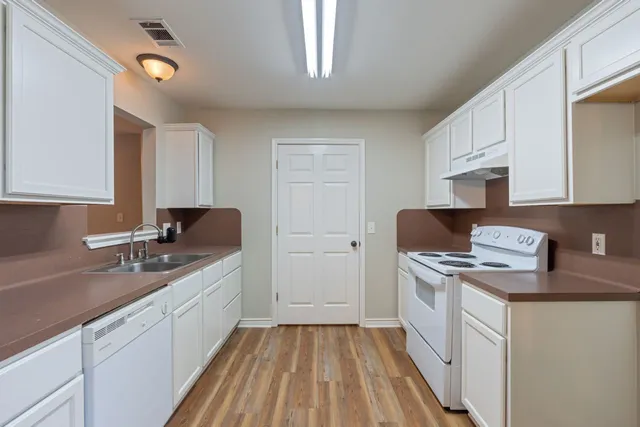 a kitchen with white cabinets and white appliances