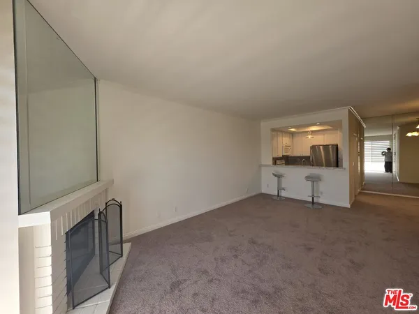 a view of a livingroom with an empty space and a fireplace