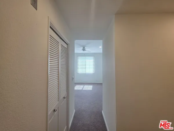 an empty room with a ceiling fan and window