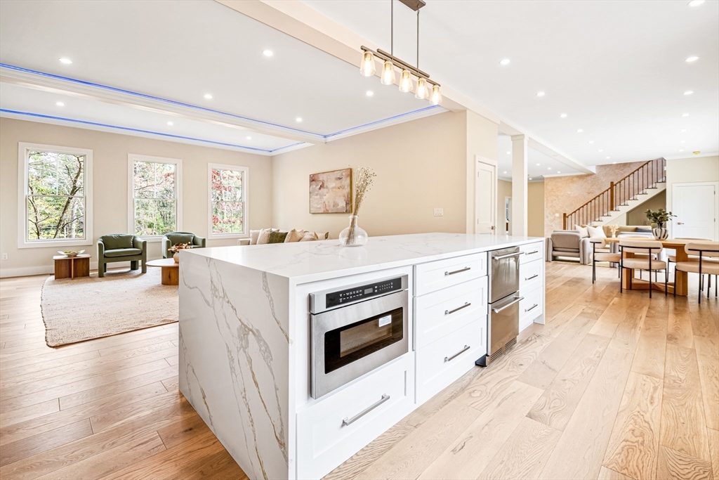 36 Oakmount Circle Lexington, MA 02420 - Photo 19 of 42 a large white kitchen with a large window a island a stove a table and chairs