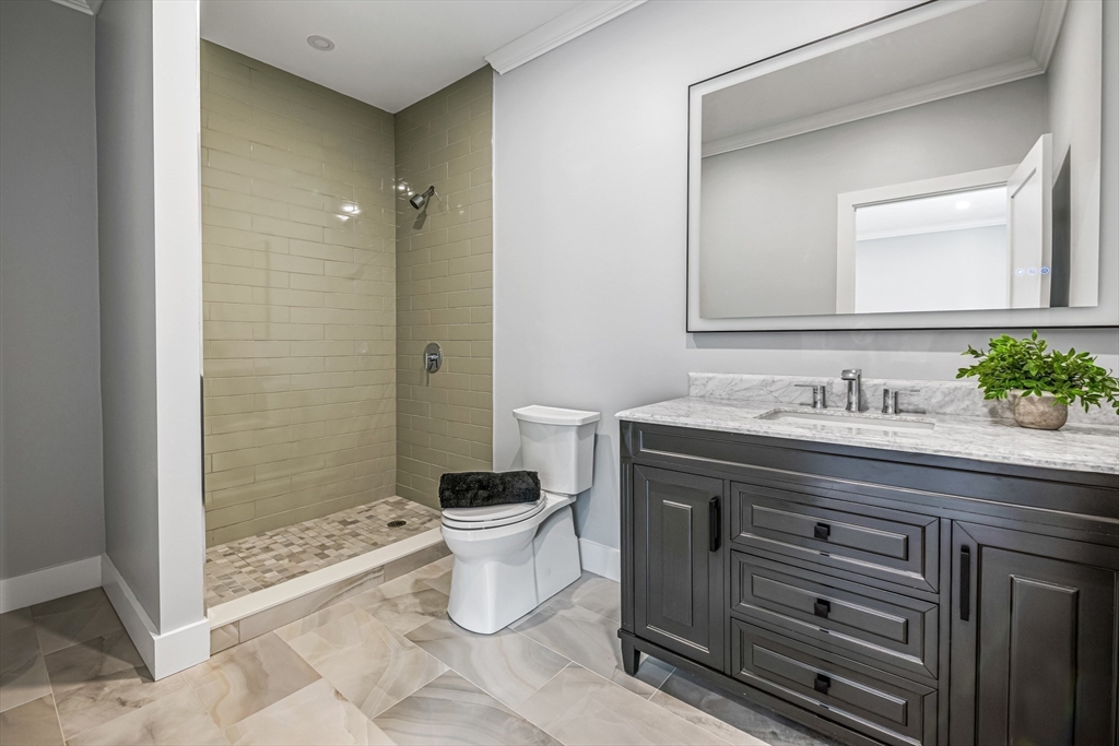 36 Oakmount Circle Lexington, MA 02420 - Photo 37 of 42 a spacious bathroom with a granite countertop sink a toilet a mirror and shower