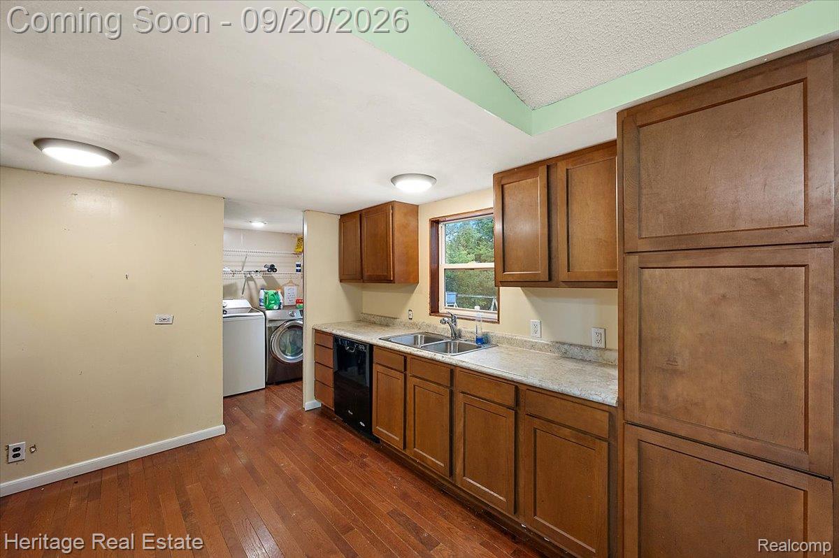 3337 Le Valley Road Columbiaville, MI 48421 - Photo 12 of 57 Wood-finish flooring, wood cabinetry, light-toned countertops, double basin sink, and recessed ceiling lighting