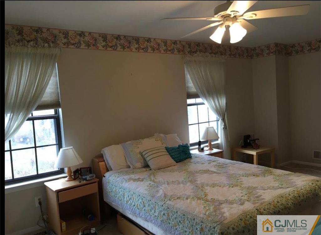1504 Maplecrest Road Edison, NJ 08820 - Photo 12 of 15 a bedroom with a bed and a chandelier