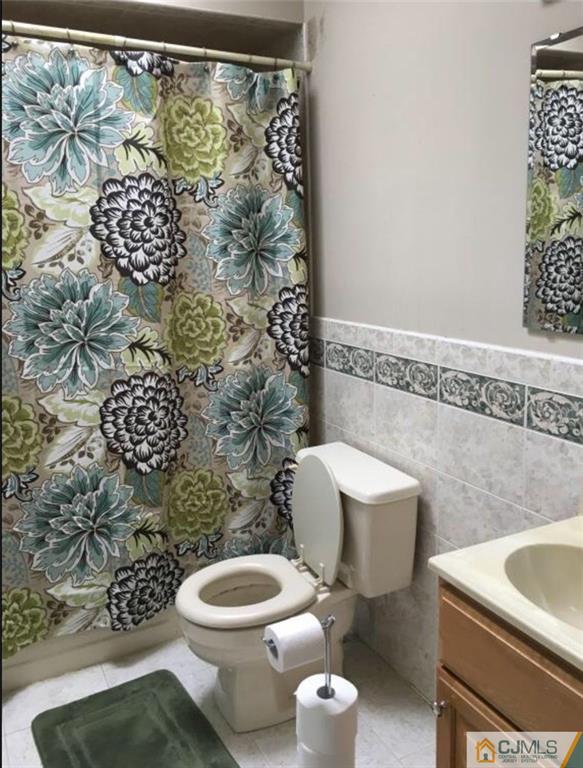 1504 Maplecrest Road Edison, NJ 08820 - Photo 13 of 15 a white toilet sitting next to a shower curtain