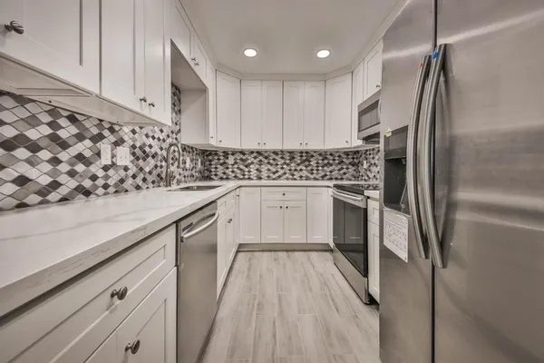 a kitchen with a sink stainless steel appliances and cabinets