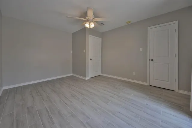 a view of an empty room with wooden floor