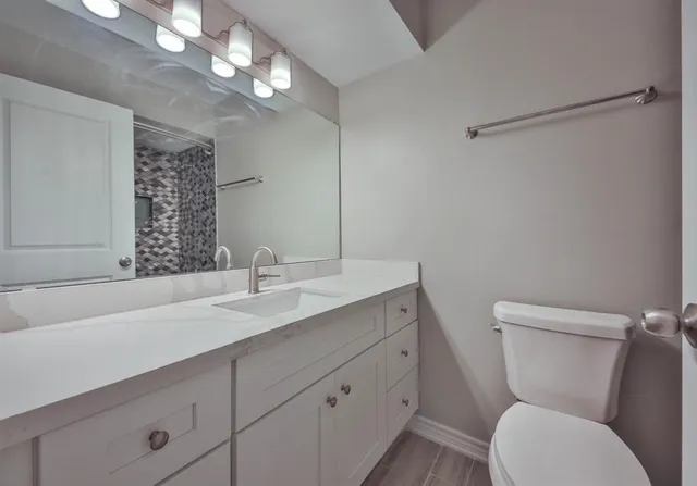 a bathroom with a toilet sink and mirror