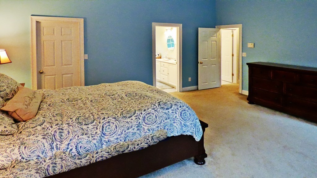 255 Holmes Street Hanson, MA 02341 - Photo 19 of 34 a bed sitting in a spacious bedroom next to a window and a dresser