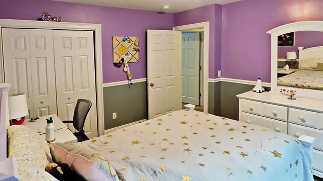 a bedroom with a bed table and chair
