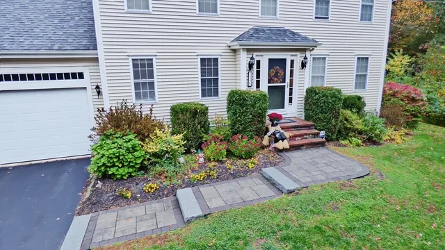 a front view of a house with a yard and potted plants