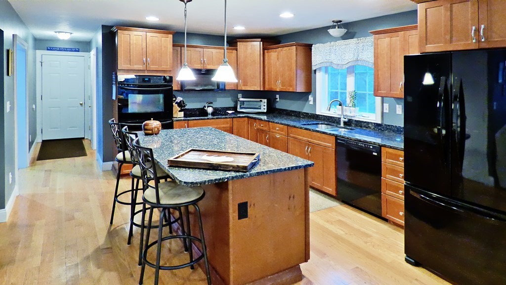 255 Holmes Street Hanson, MA 02341 - Photo 5 of 34 a kitchen with stainless steel appliances granite countertop a sink a stove and a refrigerator