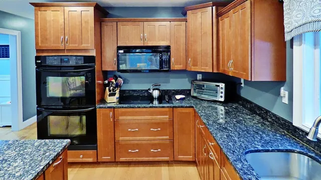 a kitchen with stainless steel appliances granite countertop a stove a sink and a microwave