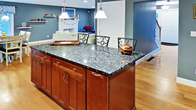 a kitchen with stainless steel appliances granite countertop a sink dishwasher stove and refrigerator with wooden floor