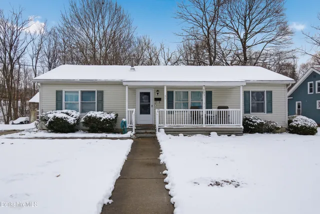 a view of a house with a yard covered in snow