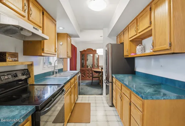 a kitchen with granite countertop a sink stove and cabinets