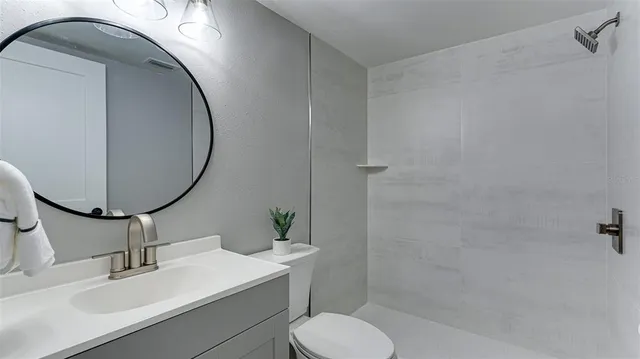 a bathroom with a sink toilet and a mirror