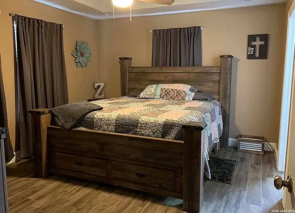 a bed sitting in a bedroom next to a window with wooden floor