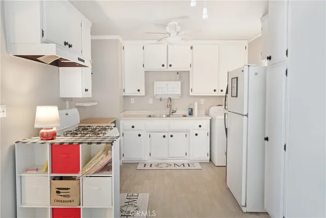 a kitchen with stainless steel appliances a stove a refrigerator and white cabinets
