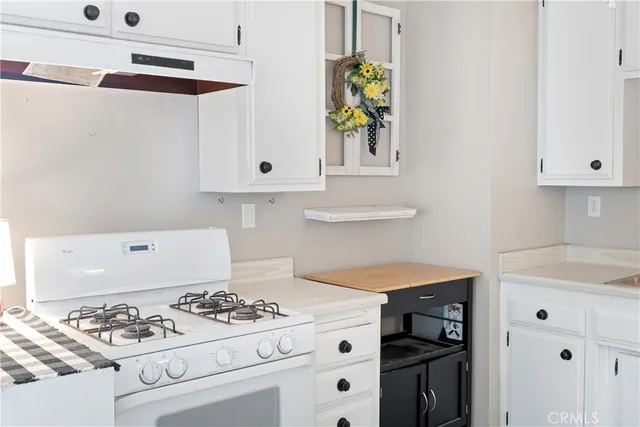 a kitchen with white cabinets and appliances