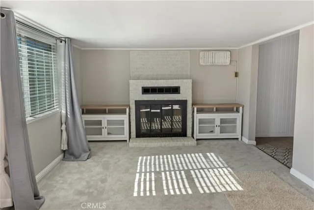 a view of an empty room with a fireplace and a window