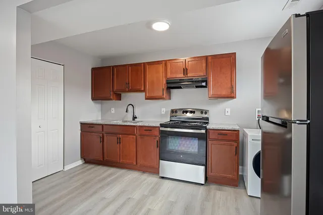 a kitchen with stainless steel appliances granite countertop a stove a sink and a refrigerator