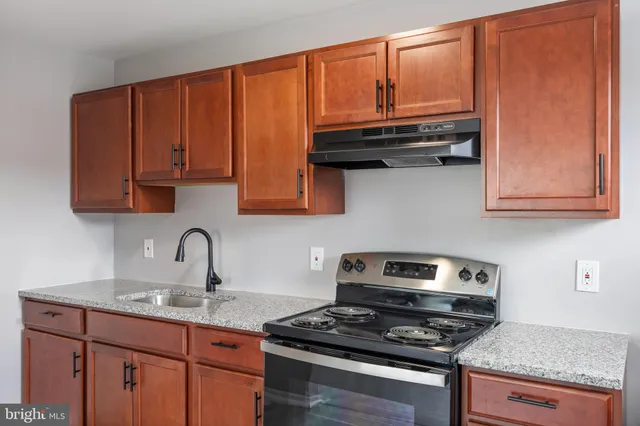 a kitchen with wooden cabinets and a stove top oven