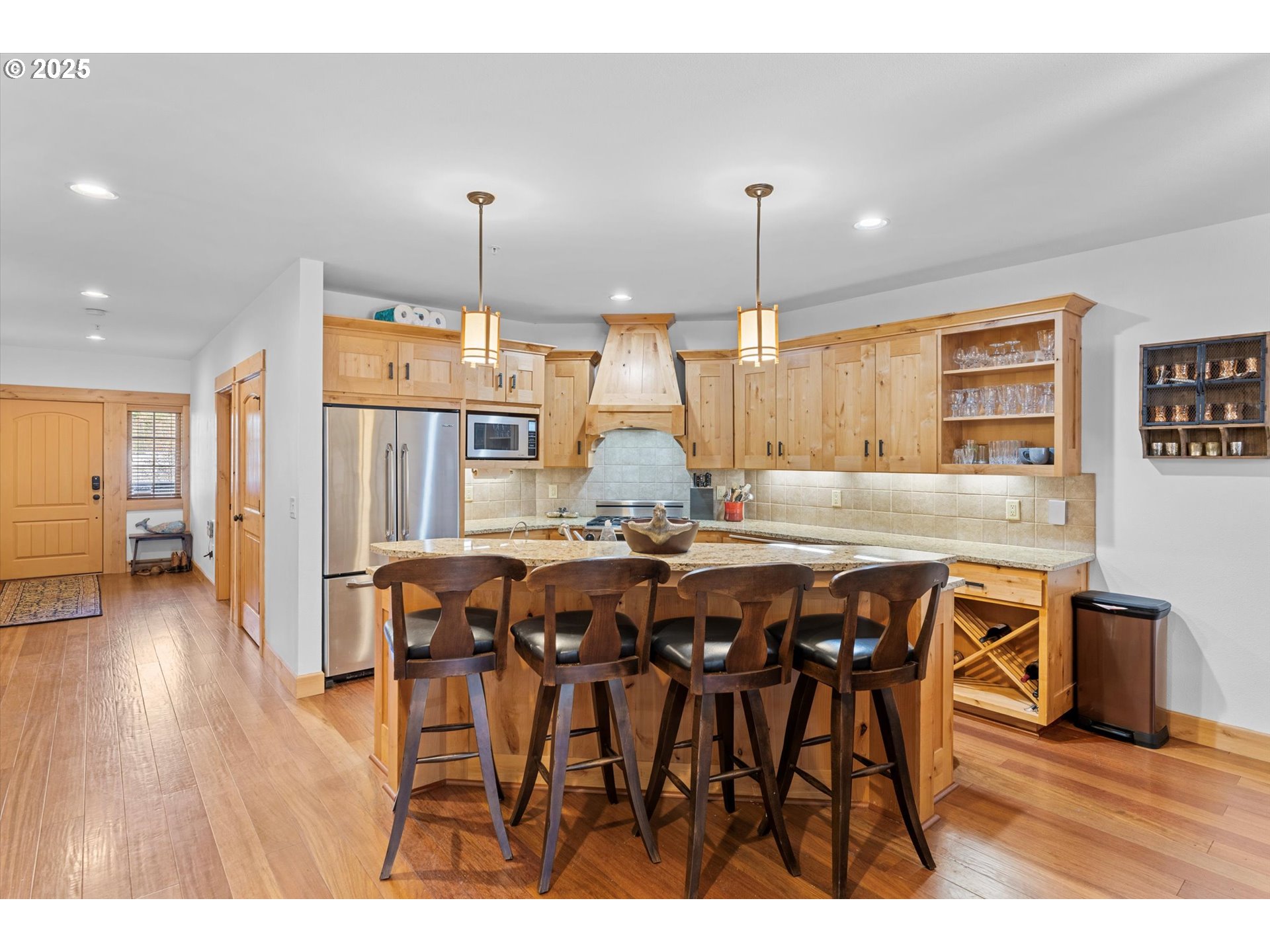 31200 East Collins Lake Road, Unit 1 Government Camp, OR 97028 - Photo 6 of 38 a dining hall with stainless steel appliances kitchen island granite countertop a table chairs and a refrigerator