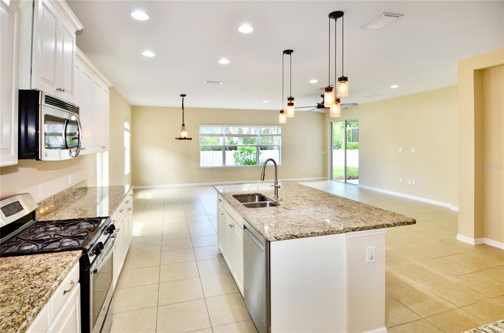 205 Cohosh Road Nokomis, FL 34275 - Photo 21 of 79 a kitchen with stainless steel appliances granite countertop a sink a stove and a wooden floors
