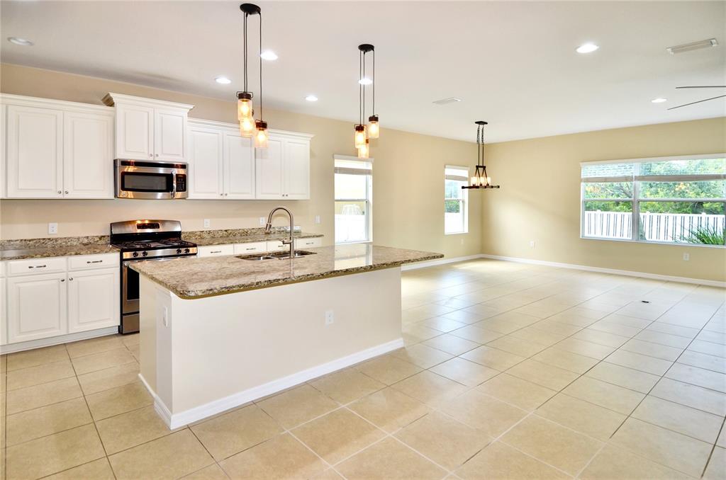 205 Cohosh Road Nokomis, FL 34275 - Photo 22 of 79 a kitchen with stainless steel appliances granite countertop a sink a stove a microwave a counter top space cabinets and a window