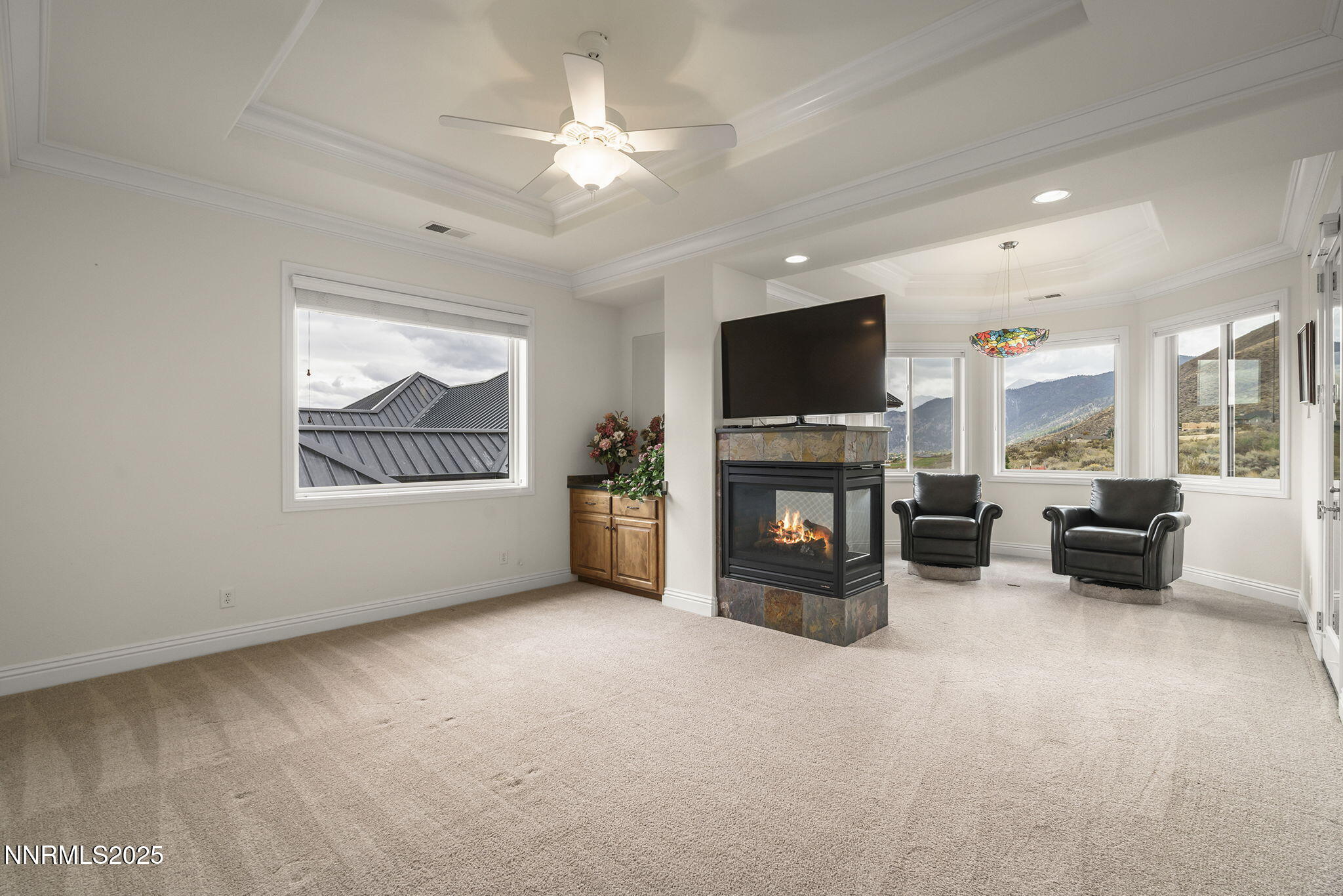 345 James Canyon Loop Genoa, NV 89411 - Photo 20 of 54 an empty room with furniture a flat screen tv and a fireplace