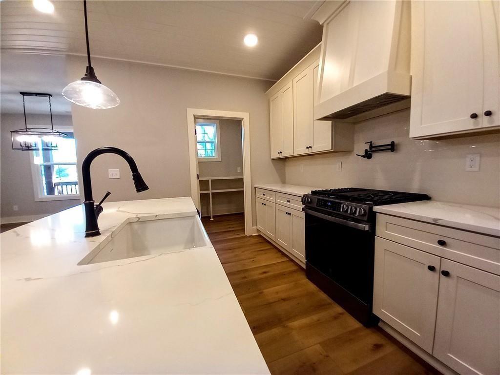 136 Rainey Road Temple, GA 30179 - Photo 34 of 78 a kitchen with kitchen island stainless steel appliances a sink a stove and a wooden floors