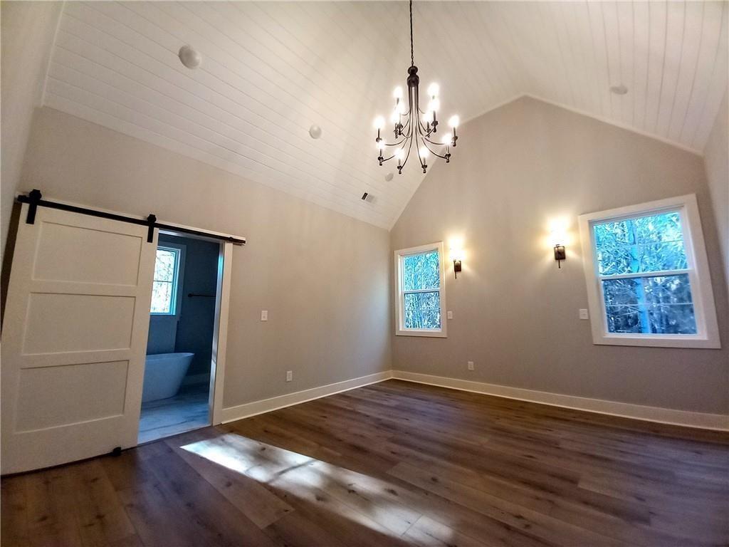 136 Rainey Road Temple, GA 30179 - Photo 43 of 78 an empty room with wooden floor chandelier and windows