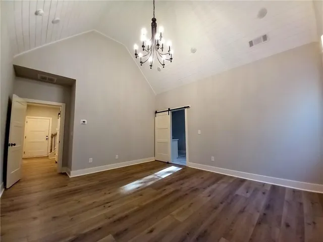 an empty room with windows and chandelier fan