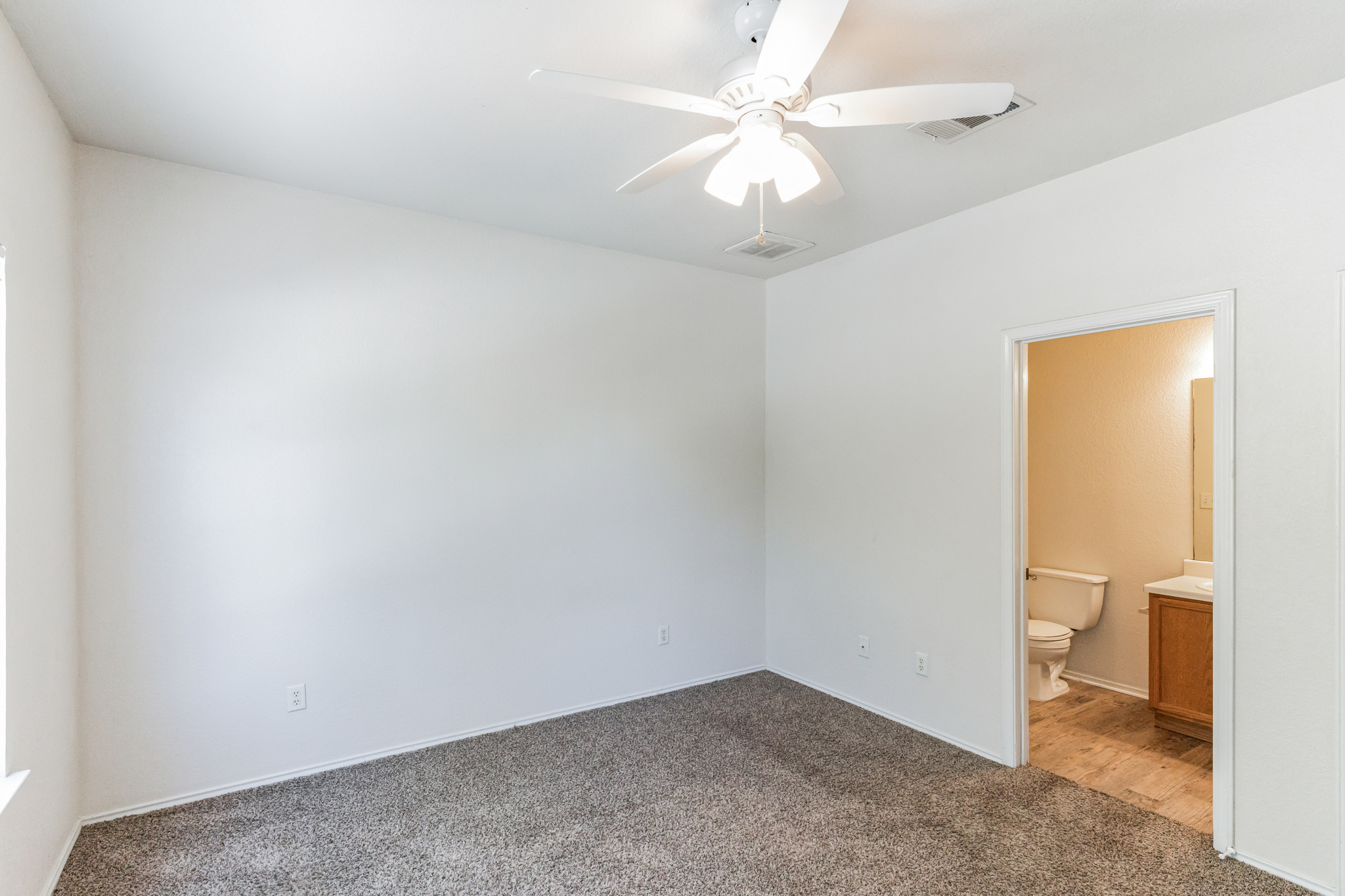 1107 East 3rd Street Georgetown, TX 78626 - Photo 22 of 36 Unfurnished bedroom with carpet flooring, ensuite bathroom, and ceiling fan