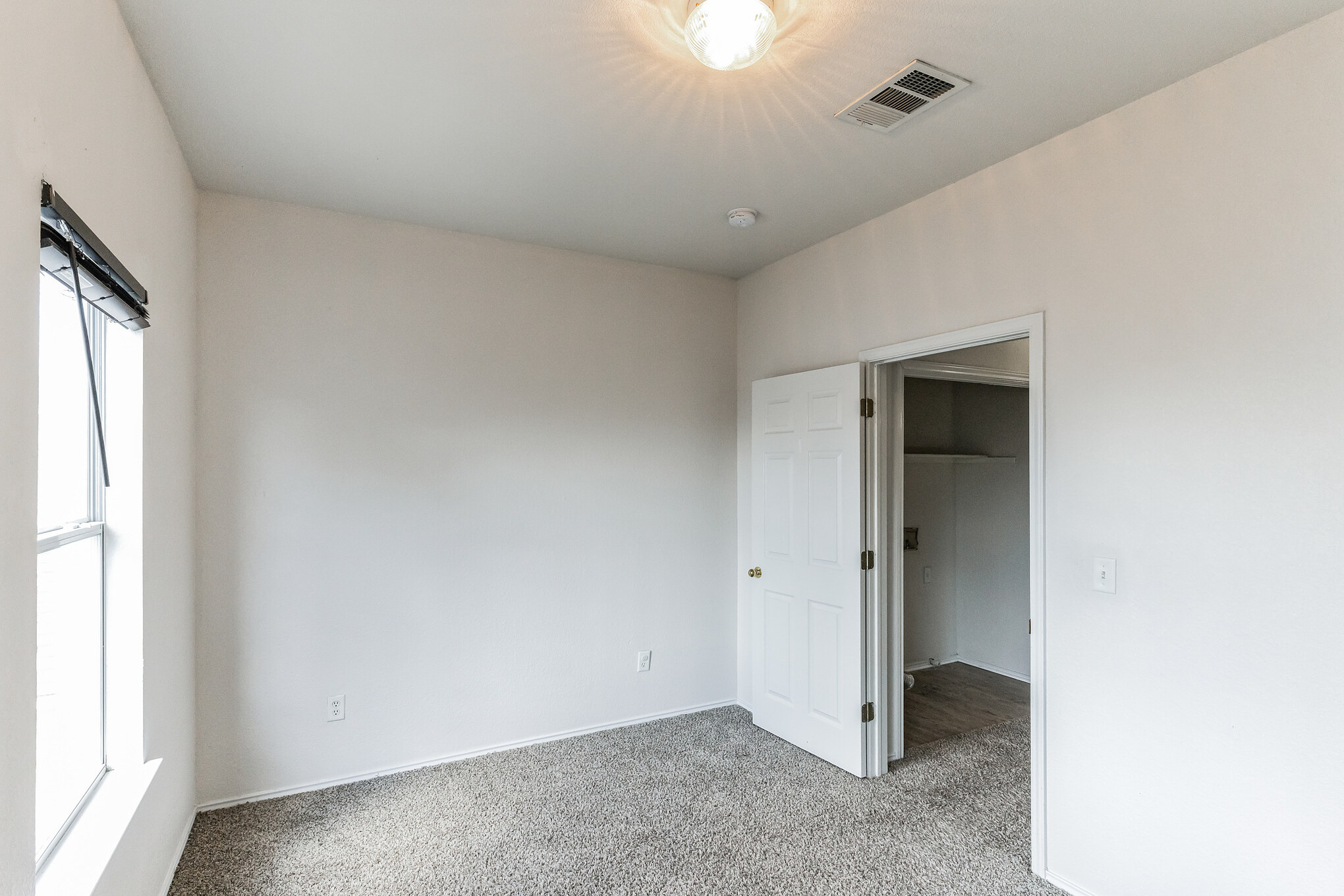 1107 East 3rd Street Georgetown, TX 78626 - Photo 25 of 36 Unfurnished bedroom featuring light carpet and a walk in closet