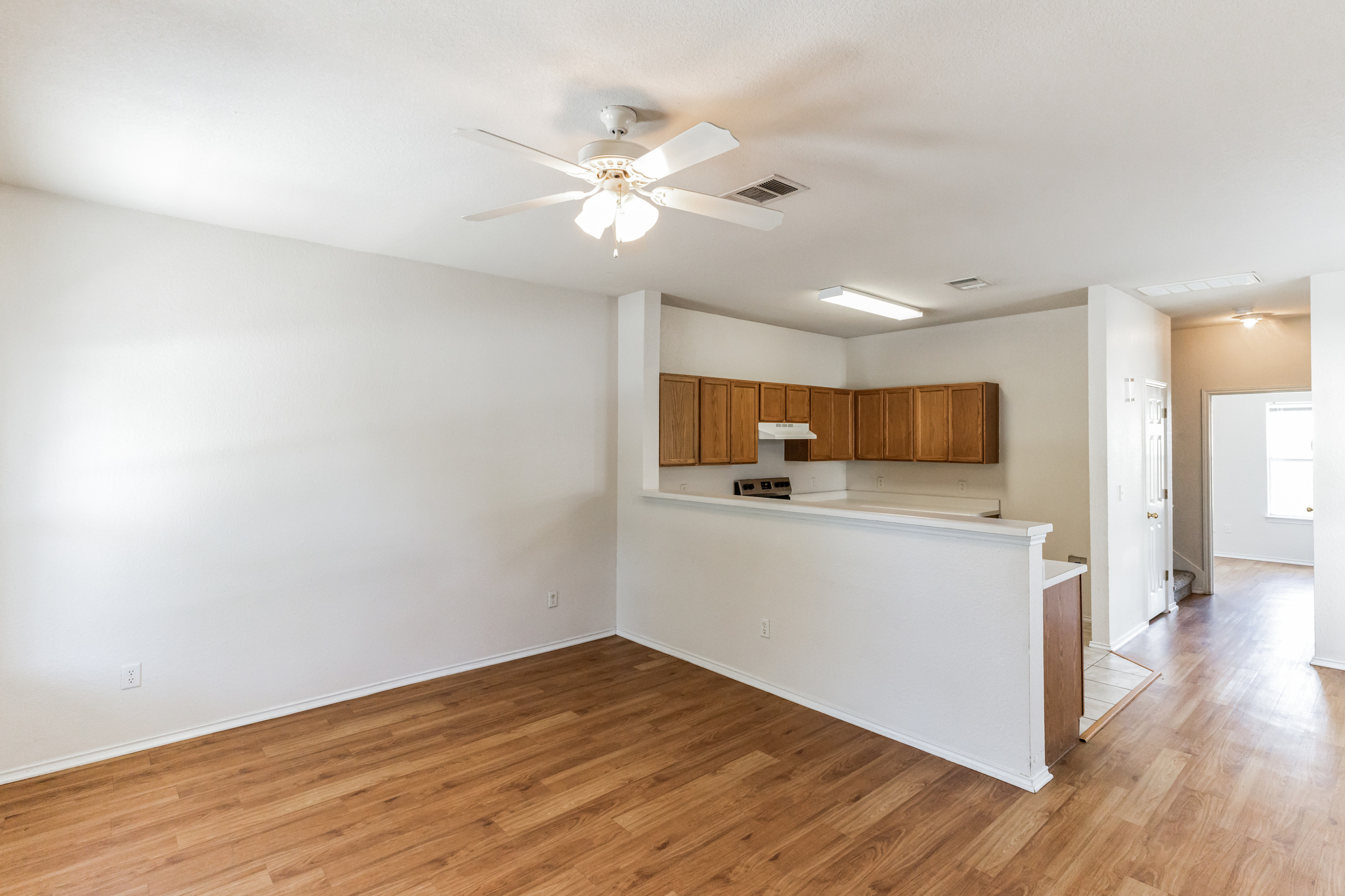 1107 East 3rd Street Georgetown, TX 78626 - Photo 4 of 36 Kitchen featuring a ceiling fan, light wood finished floors, a peninsula, and light countertops