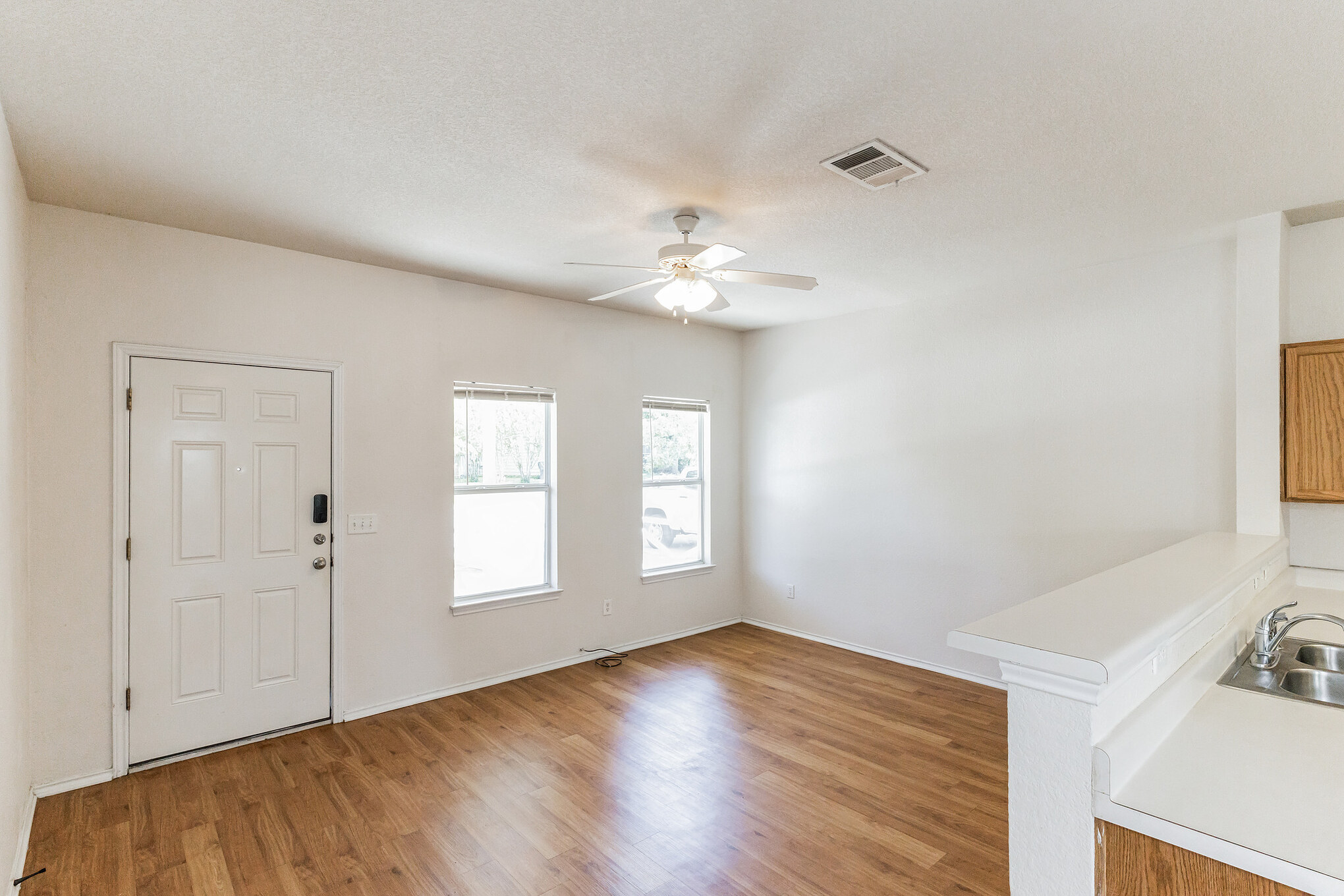 1107 East 3rd Street Georgetown, TX 78626 - Photo 6 of 36 Foyer entrance with a ceiling fan, light wood finished floors, and a textured ceiling