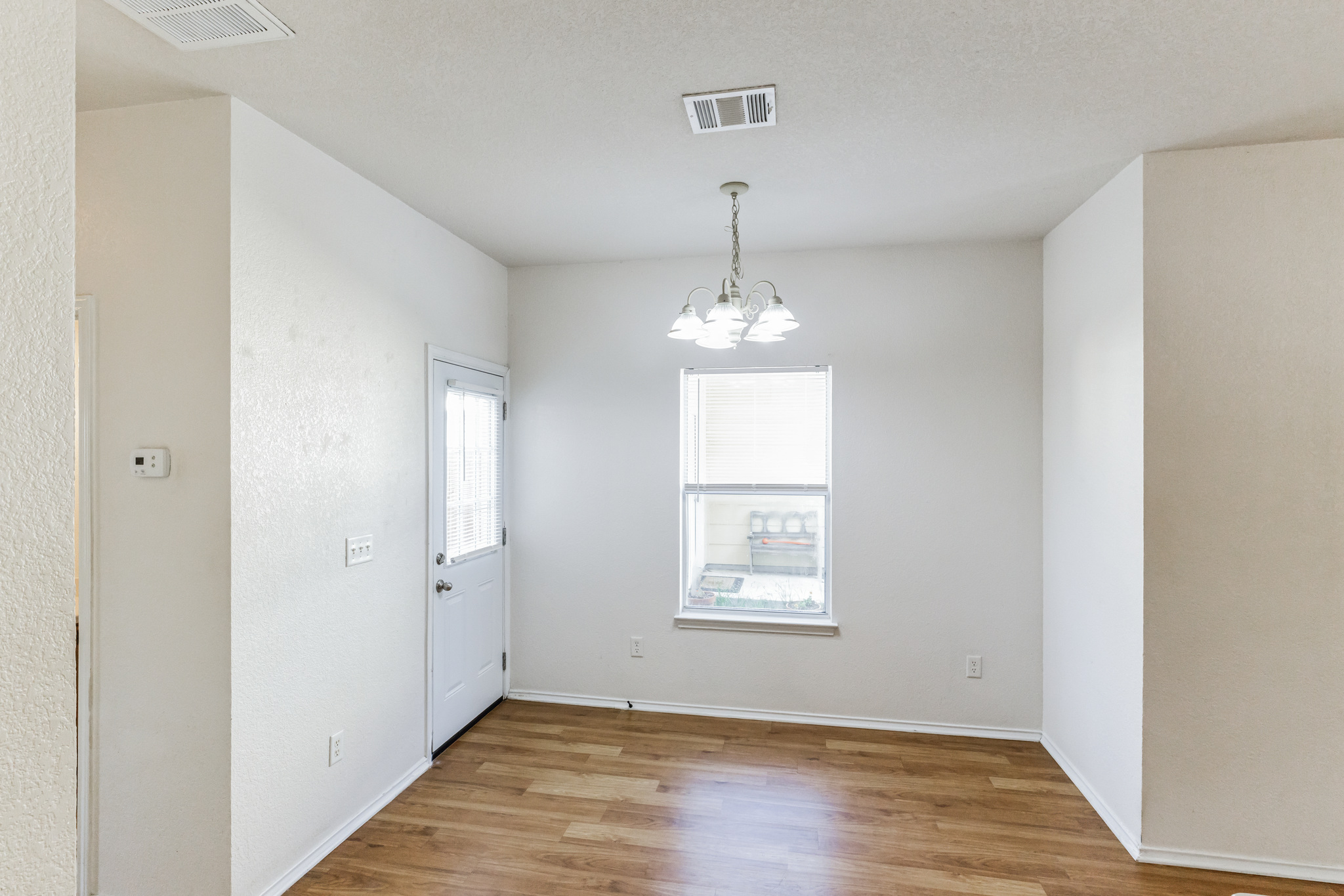 1107 East 3rd Street Georgetown, TX 78626 - Photo 10 of 36 Unfurnished dining area with a chandelier and light wood-style flooring