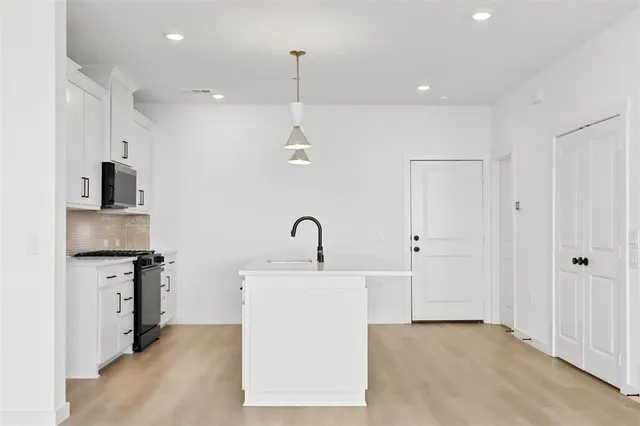 a kitchen with kitchen island a sink stainless steel appliances and cabinets