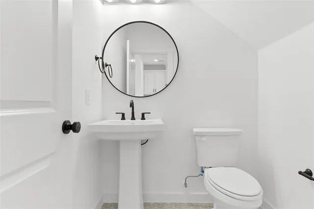 a bathroom with a toilet a sink and a mirror