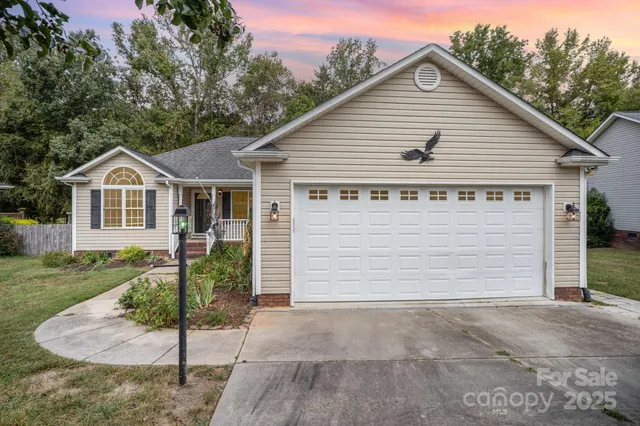a view of a small house in front of a house with plants and large tree