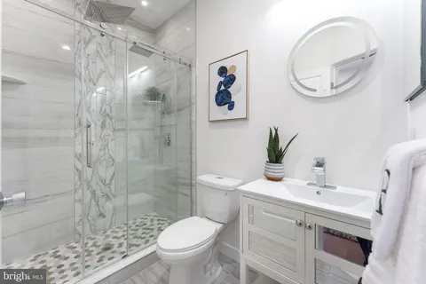 a bathroom with a sink a toilet and a mirror