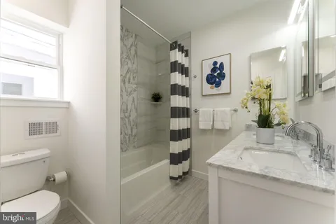 a bathroom with a granite countertop sink toilet and shower
