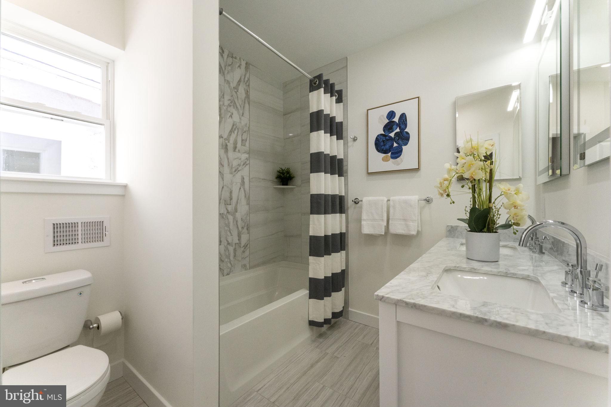 2030 Tasker Street Philadelphia, PA 19145 - Photo 23 of 29 a bathroom with a granite countertop sink toilet and shower